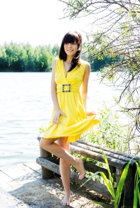 Young brunette girl in a yellow dress flashes her girl parts by a river 17807052