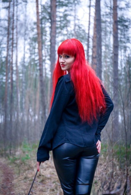 Redhead Ferggy pulls down leather pants to get at her horny cunt in the woods 80807178