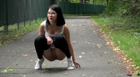 Glasses wearing chick pulls down her legging for a quick piss on on paved lot 47757318