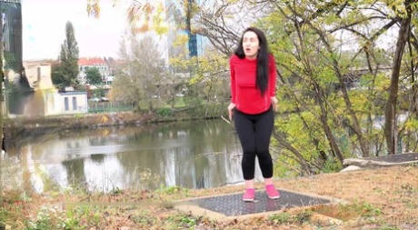 Dark haired girl Corin pulls down leggings for a pee on a grate by the river 42428020