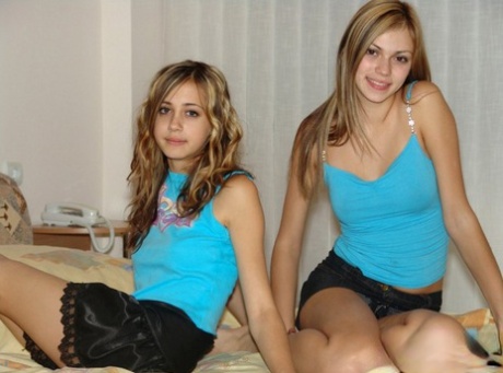 Young lesbians Laura & Katrina uncover small tits on a bed in black skirts 72627160