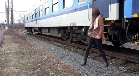 Cynthia Vellons pulls down black tights for a quick piss near railway cars 52536566