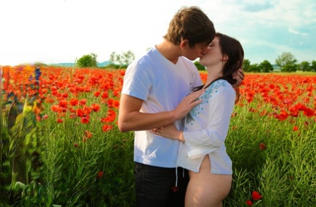 Teen couple have sexual intercourse in a field of blooming flowers 96240268