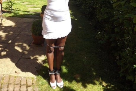 Black girl is cleaved gagged and bound with her hands above her head in a yard 32320395