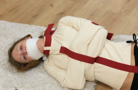 Barefoot girl is silenced with a gag while restrained in a straitjacket 69749985