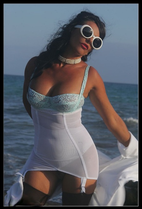 Dark haired MILF frees her tits from a girdle at the ocean in retro nylons 70627267