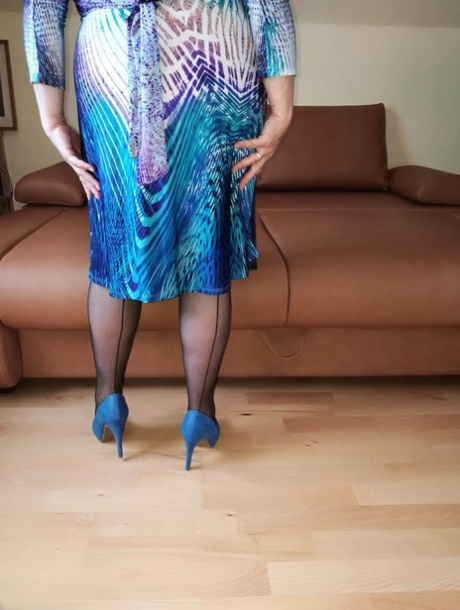 Naughty granny exposes her boobs while changing attire in nylons and heels 48321075