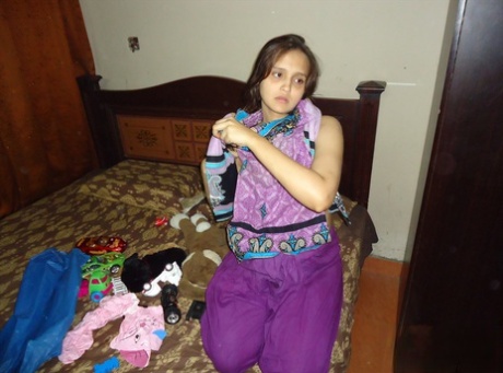 Pregnant Indian girl moisturizes after a shower before getting dressed 77442676