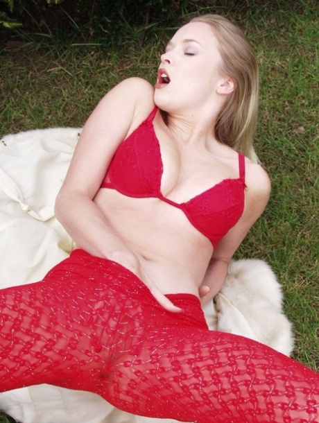 Blonde British beauty Tamara Noon pulls down red hose while in a yard 11632618