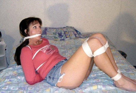 Caucasian girl is cleaved gagged and left tied up on a bed in her clothes 22085915