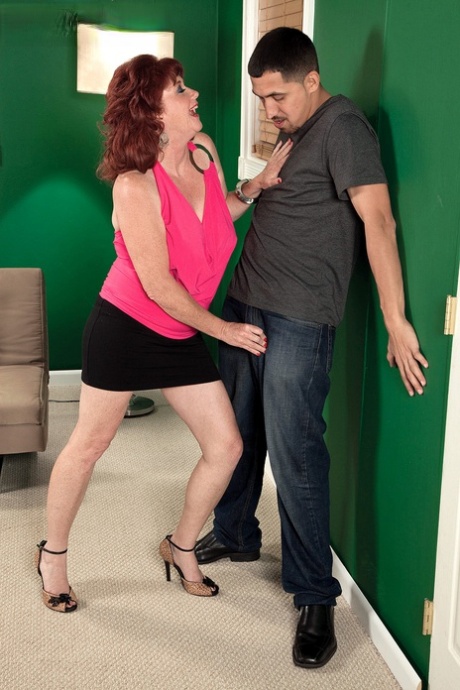 Mature redhead Shirley Lily seduces a younger Latino man in a black miniskirt 97967249