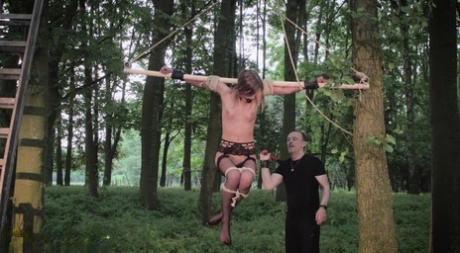 Caucasian girl is suspended upside down from a tree while being flogged 22882291