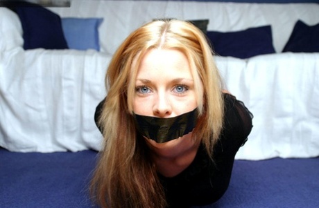 Natural blonde with blue eyes is left duct taped and hog tied in clothing 92952373