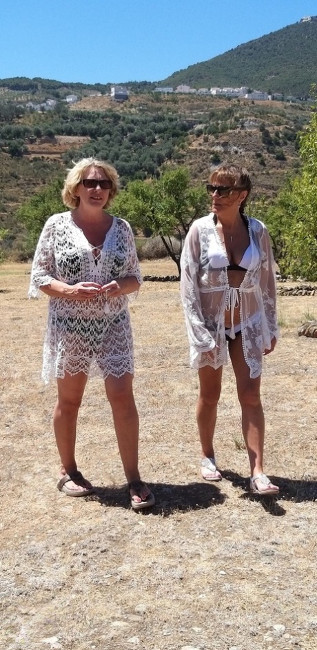 Mature lesbians share a double ended dildo during outdoor sex on blankets 72802385