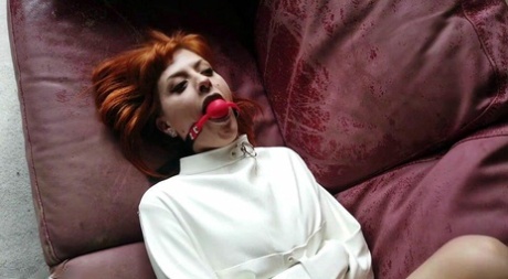 Natural redhead sports a ball gag while restrained with a straitjacket 85039416