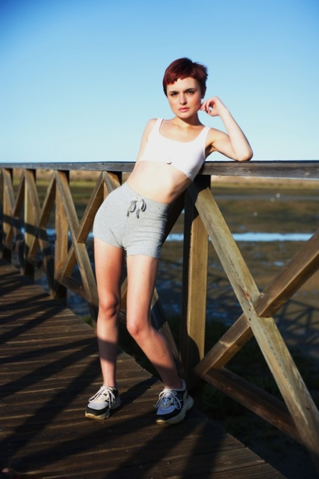 Solo girl with short red hair and freckles puffs on a smoke after getting wet 96665305