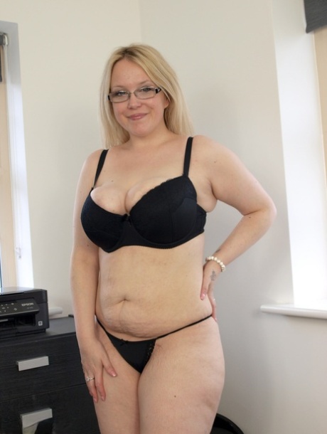 Blonde British plumper Sindy Bust goes nude on a bed in glasses and heels 85271170