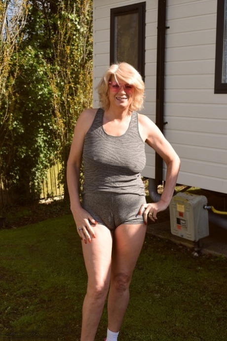 Mature blonde Dimonty reveals her natural tits while going about her business 81802658