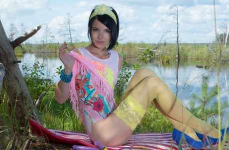 Thin brunette teen shows her nice pussy wearing a princess crown by a lake 87794850