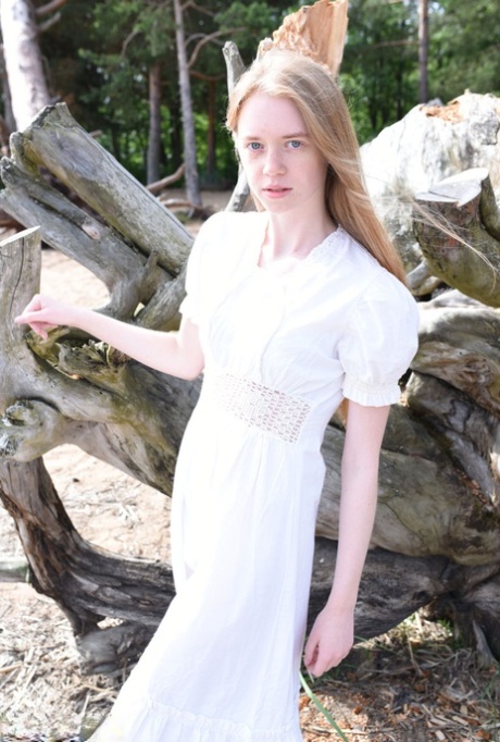 Skinny teen with red hair strips naked on beach afore weathered tree 97360896