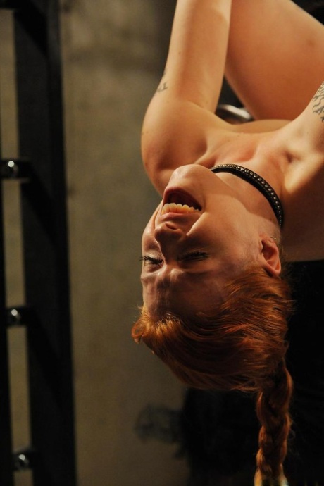 Dark-haired female punishes a suspended redheaded female with candle wax 83550895
