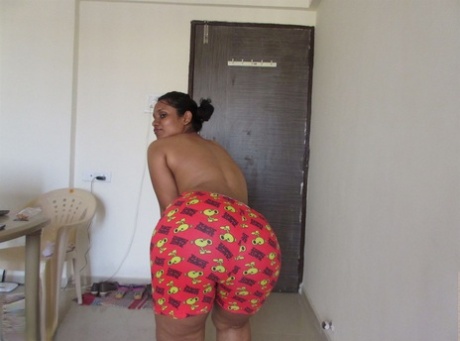 Topless Indian woman begins to pull down her shorts and underwear 53231784